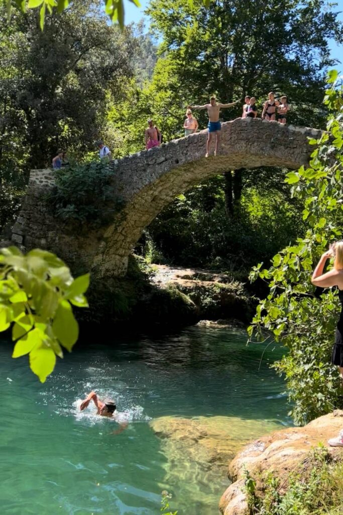 A man jumping from a bridge into the water in the South of France.